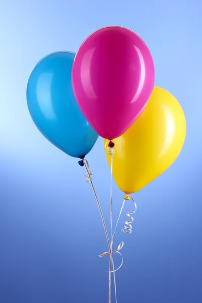 Tre färgglada ballonger på blå bakgrund — Stockfoto