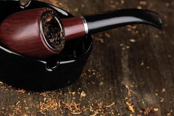 Smoking pipe and tobacco on wooden table close-up — Stock Photo, Image