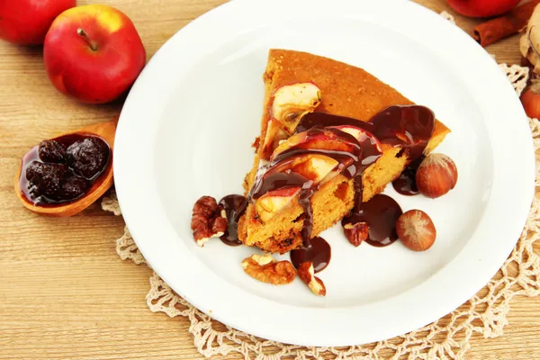 Slice of tasty homemade pie with chocolate and apples, on wooden table — Stock Photo, Image