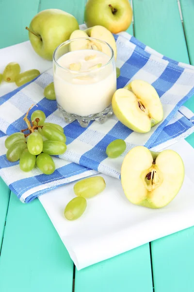 Delicious yogurt in glass with fruit on wooden table close-up — Stock Photo, Image