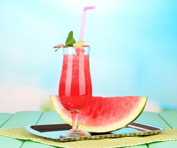 Glas mit frischem Wassermelonensaft, auf Tablett, auf Holztisch, auf hellem Hintergrund — Stockfoto