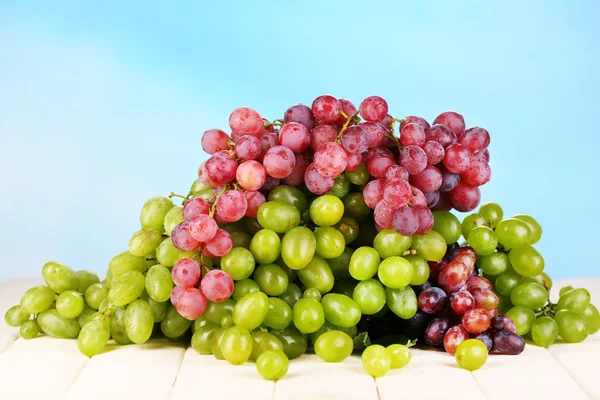Ripe green and purple grapes on wooden table on natural background — Stock Photo, Image