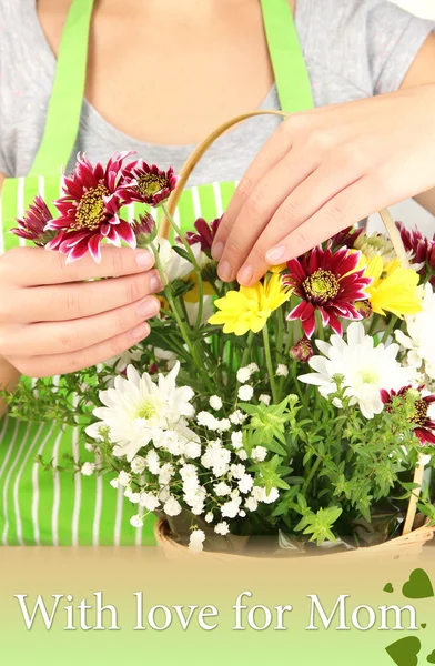 Florist makes flowers bouquet in wicker basket