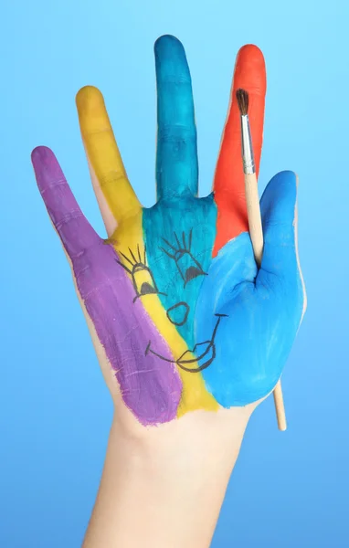 Painted hand with smile on blue background — Stock Photo, Image