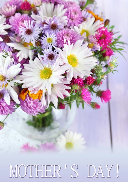 Flores silvestres em vaso de vidro em guardanapo na mesa de madeira — Fotografia de Stock