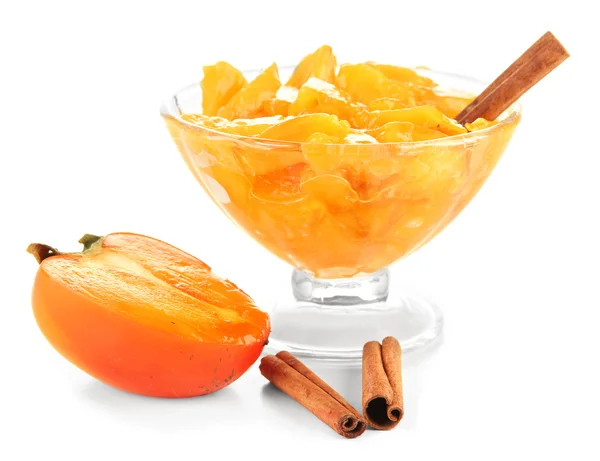 Half persimmon with jam in glass saucer and cinnamon isolated on white — Stock Photo, Image