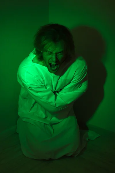 Mentally ill man in strait-jacket in room corner — Stock Photo, Image