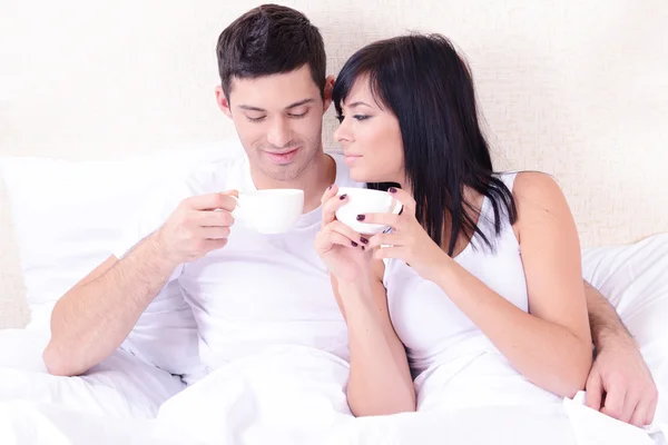 ベッドの中でコーヒーを飲むことを愛するのカップル — ストック写真