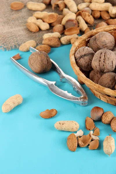 Nötknäppare med nötter på träbord närbild — Stockfoto