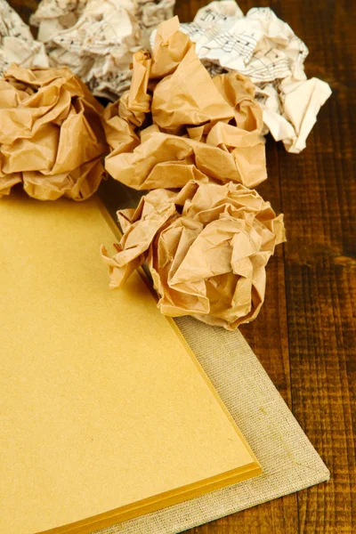 Crumpled paper balls with notebook on table close up — Stock Photo, Image