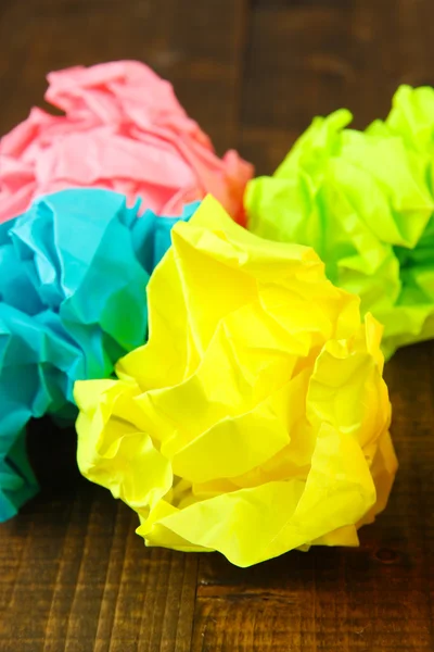 Bolas de papel amassadas coloridas no fundo de madeira — Fotografia de Stock
