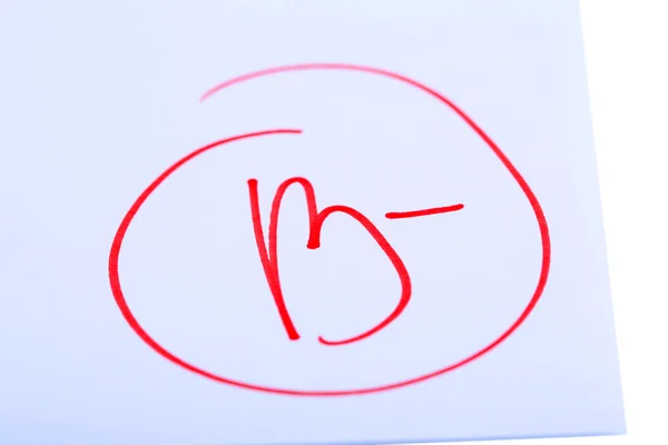 Grade B- written on an exam paper — Stock Photo, Image