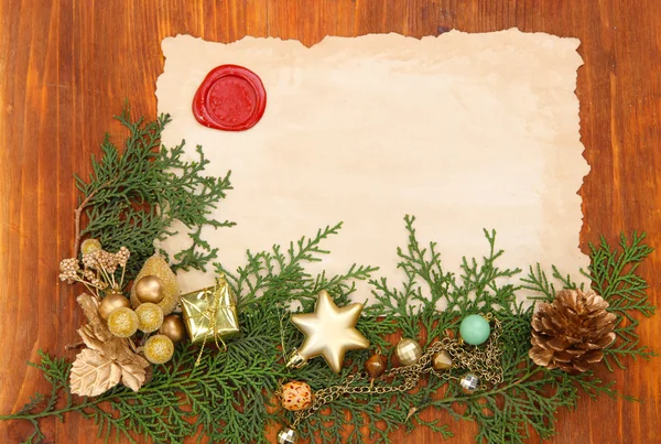 Marco con papel vintage y decoraciones navideñas sobre fondo de madera — Foto de Stock