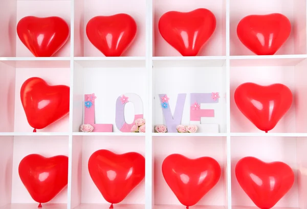 Witte planken ingericht met handgemaakte brei word en ballonnen — Stockfoto