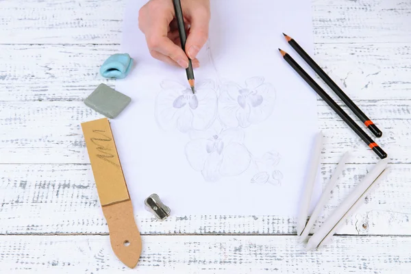 el ile profesyonel sanat malzemeleri, üzerinde beyaz izole bir kroki çizer