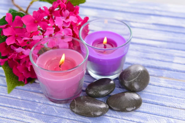 Beautiful colorful candles and flowers,on color wooden background — Stock Photo, Image