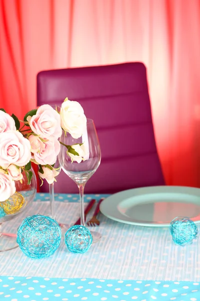 Mesa que serve com utensílios de mesa coloridos no fundo do quarto — Fotografia de Stock
