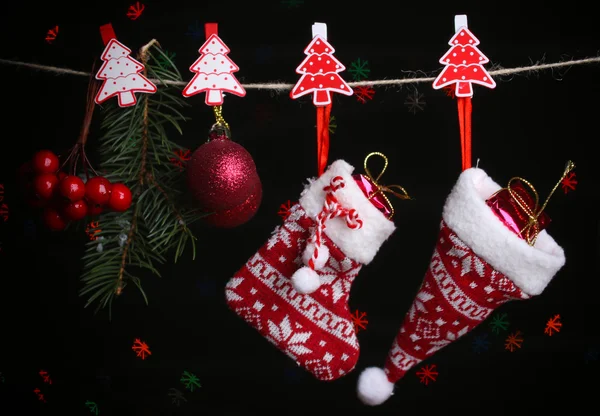 Calcetín de Santa, sombrero y accesorios navideños sobre fondo negro con luces —  Fotos de Stock