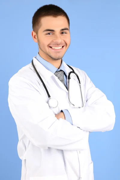 Male Doctor standing with folder, on blue background — Stock Photo, Image