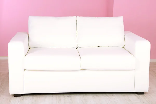 在房间里粉红色的背景上的白色沙发 — 图库照片