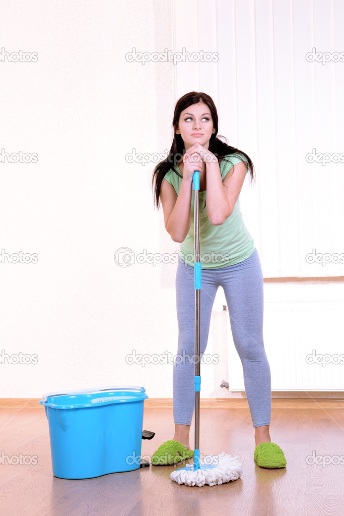 Young housewife with mop in room