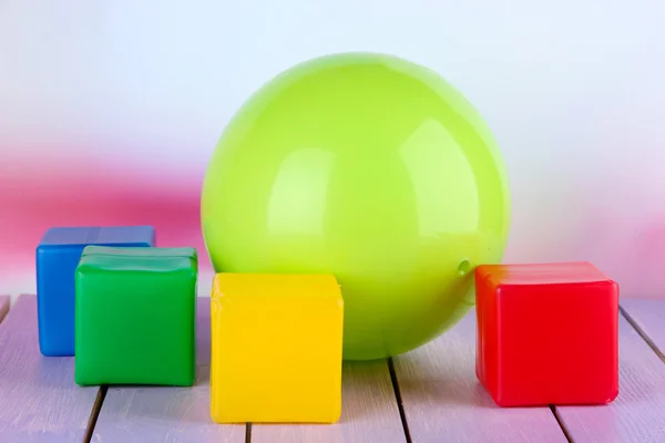 Bola brilhante e cubos coloridos na mesa sobre fundo brilhante — Fotografia de Stock