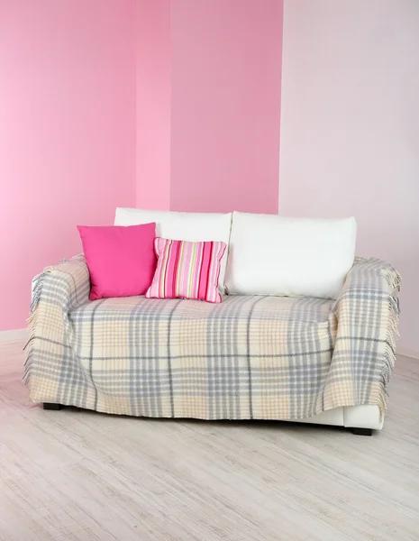 Λευκό καναπέ στην αίθουσα σε φόντο ροζ τοίχο — Φωτογραφία Αρχείου