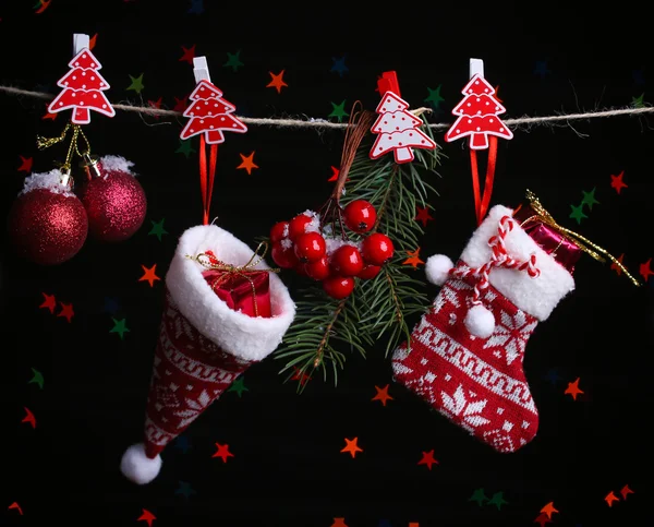 Santa sock, hat and Christmas accessories on black background with lights — Stock Photo, Image