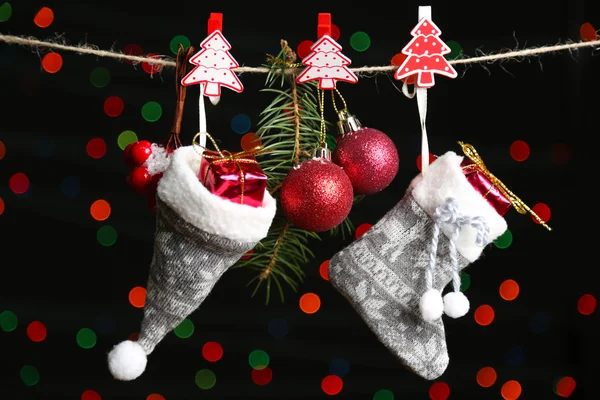 Santa sock, hat and Christmas accessories on black background with lights — Stock Photo, Image