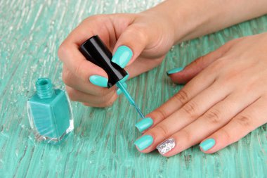 Mavi manikür, renkli arka plan üzerinde elleriyle güzel kadın