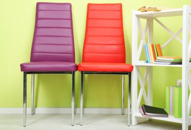 modern renkli sandalyeler, ahşap stand, duvar fon üzerine kitap ile güzel iç