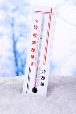 Thermometer in snow on light background clipart