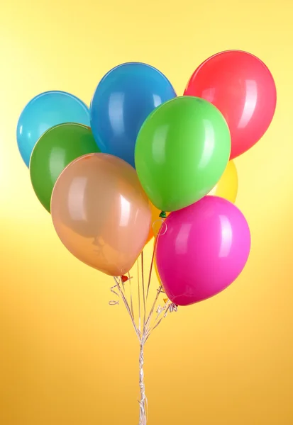 黄色背景的彩色气球 — 图库照片