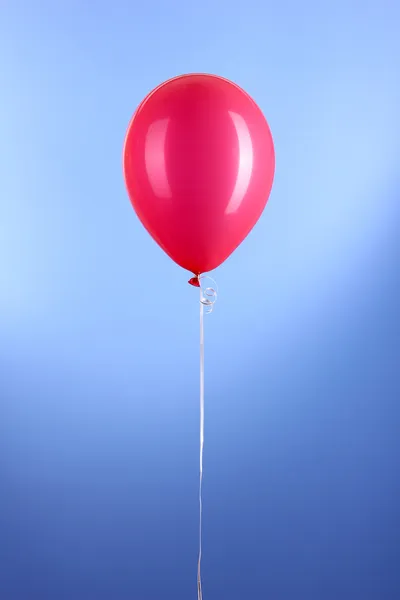 Vermelho um balão no fundo azul — Fotografia de Stock