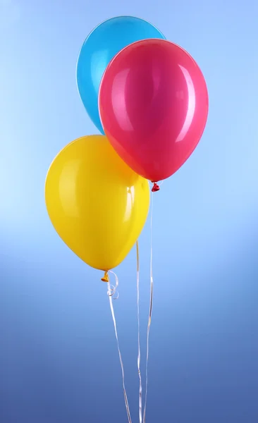 Trois ballons colorés sur fond bleu — Photo