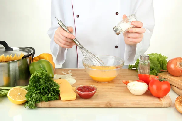 Manos femeninas mezclando huevos en un tazón de vidrio — Foto de Stock