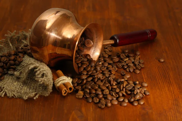 Cafetera con granos de café sobre fondo de madera marrón — Foto de Stock