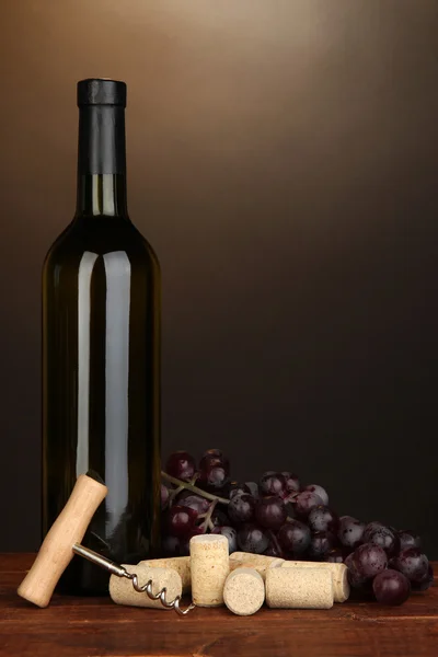 ワインと茶色の背景に木製のテーブルの上のコルク栓 — ストック写真