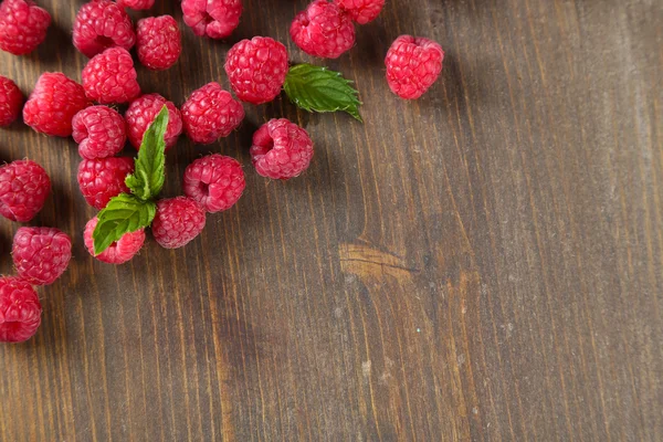 Framboises sucrées mûres sur fond de bois — Photo