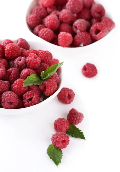 Ripe sweet raspberries in bowls, isolated on white — Stock Photo, Image