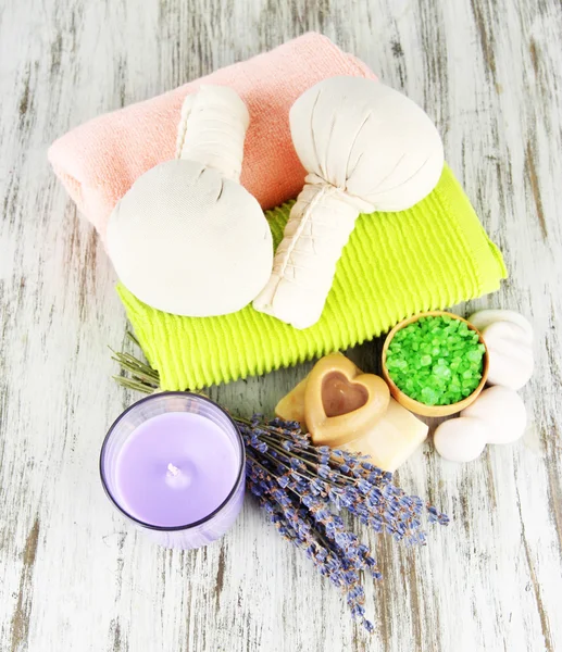 Natureza morta com vela de lavanda, sabão, bolas de massagem, sabão e lavanda fresca, sobre fundo de madeira — Fotografia de Stock