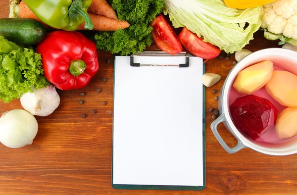 Légumes frais et épices et papier pour notes, sur fond de bois — Photo