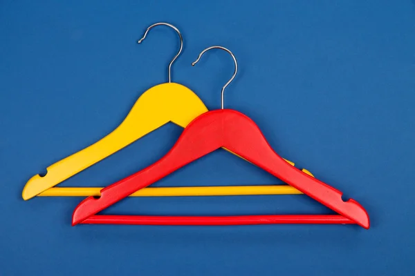 Colorful clothes hangers on blue background — Stock Photo, Image