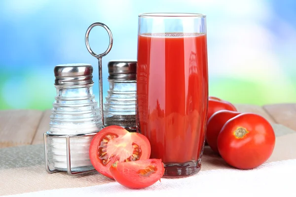 Jus de tomate en verre, sur table en bois, sur fond lumineux — Photo