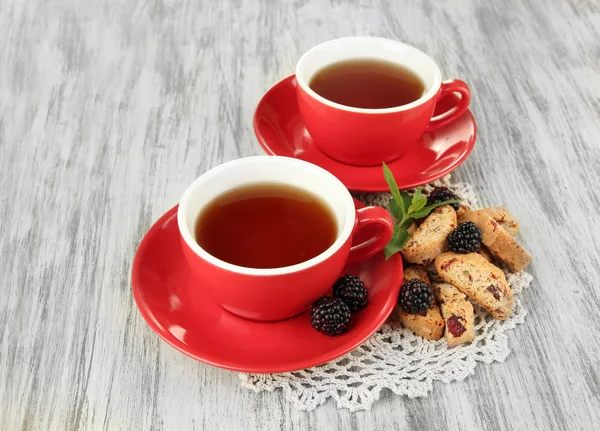 Чашки чая с печеньем и ежевикой на столе крупным планом — стоковое фото
