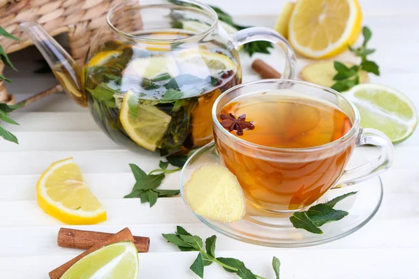 Wasserkocher und Tasse Tee mit Ingwer auf Holztisch — Stockfoto