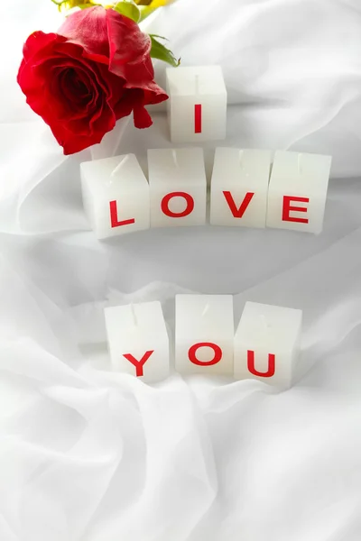 Kerzen mit bedrucktem Zeichen ich liebe dich, auf weißem Stoff Hintergrund — Stockfoto