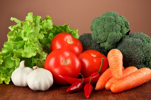 Sammansättningen av olika grönsaker på träbord på brun bakgrund — Stockfoto