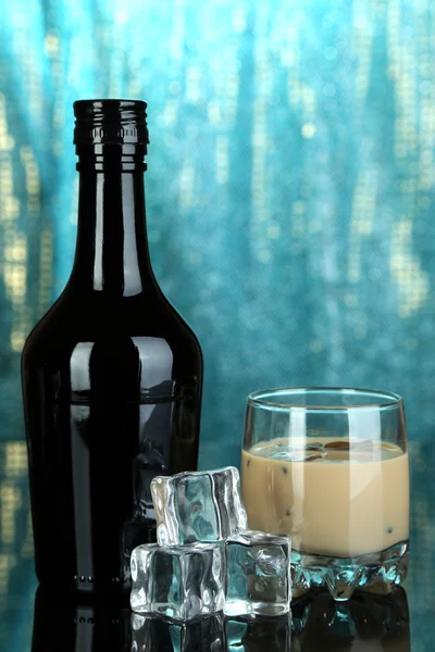 Baileys Likör in Flasche und Glas auf blauem Hintergrund — Stockfoto