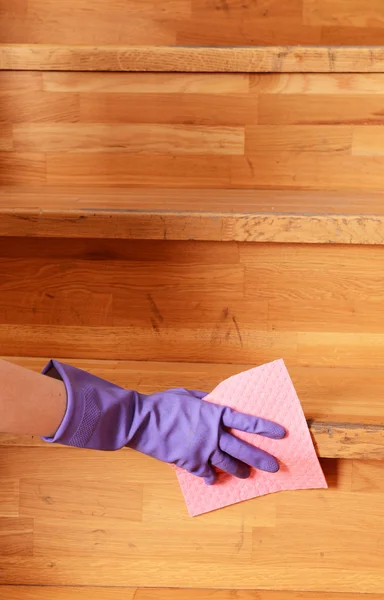 Female hand in rubber glove cleaning staircase